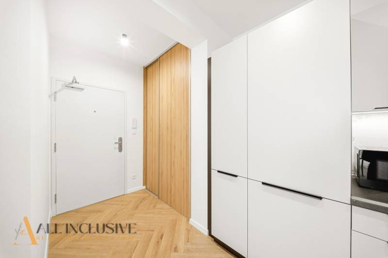 Eingangsflur in einer 4-Zimmer-Wohnung mit Holzboden und Einbauschränken.