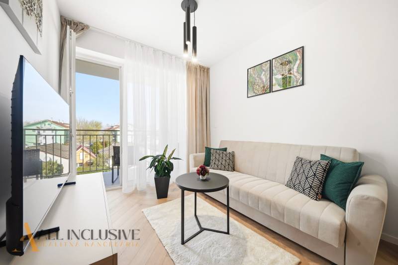 Wohnzimmer in einer 4-Zimmer-Wohnung mit Balkon, Sofa und Boden in Holzoptik.