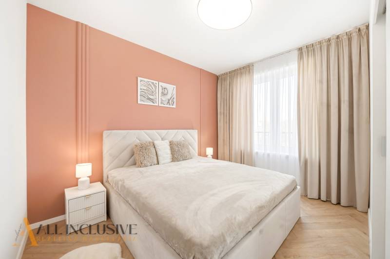 Schlafzimmer mit orangefarbener Wand und Holzboden in einer 4-Zimmer-Wohnung.