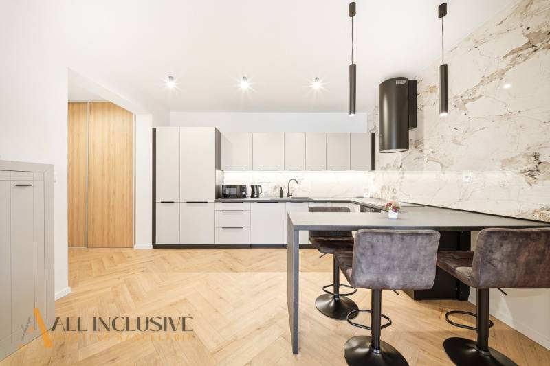 Küche in einer 4-Zimmer-Wohnung mit Holzboden und stilvollen Leuchten.