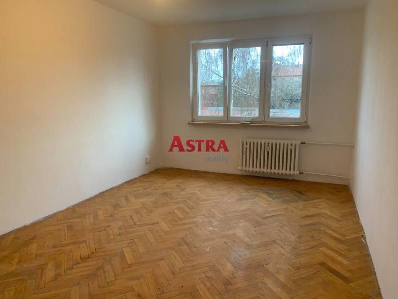 Ein Zimmer in einer 2-Zimmer-Wohnung mit einem Boden in Holzoptik und einem großen Fenster.