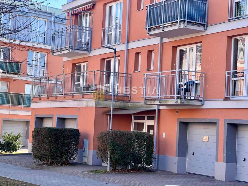 Das Bild zeigt die Außenansicht eines Wohnhauses mit Balkonen und Garagen in einer Einzimmerwohnung.