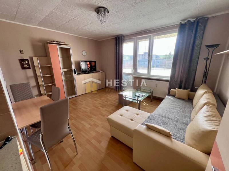 Wohnzimmer in einer 2-Zimmer-Wohnung mit Holzboden, beiges Sofa, Esstisch.