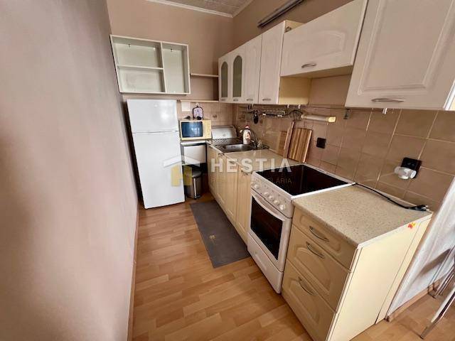 Küche in einer 2-Zimmer-Wohnung mit Holzboden und hellen Schränken.