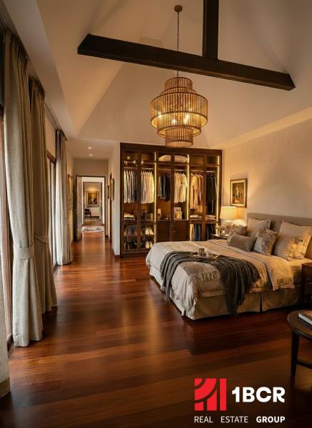 Stilvolles Schlafzimmer in einer Villa mit Holzboden und offenem Kleiderschrank.