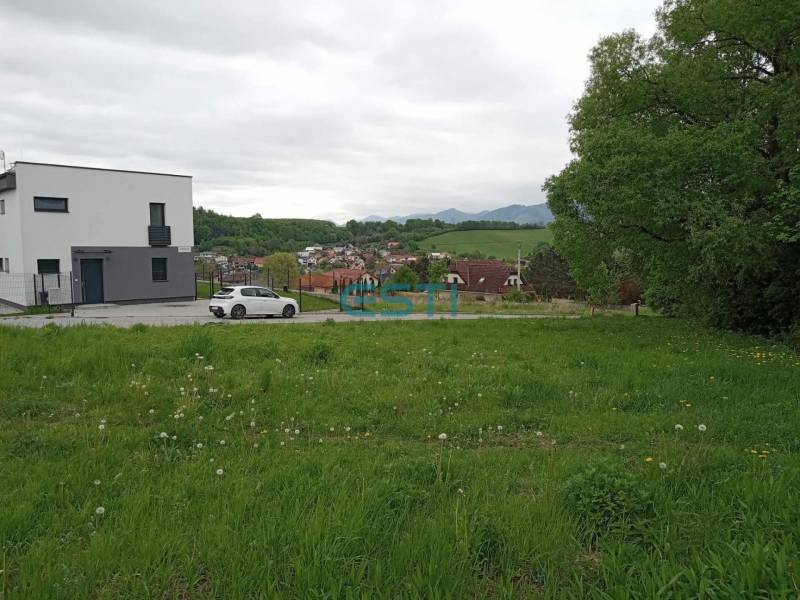 Grundstücke - Wohnen in Žilina auf der Chotárna zeigen eine grüne Wiese mit einem modernen Gebäude und einem Auto.