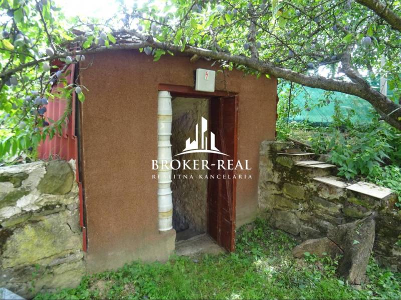 Ein kleiner Gartenschuppen neben einer Steinmauer im Garten des Einfamilienhauses Goncruszka.