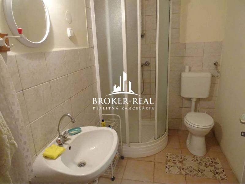 Badezimmer in einem Einfamilienhaus mit Waschbecken, Dusche und Toilette.