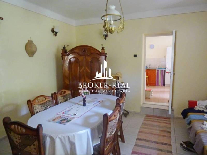 Esszimmer in einem Einfamilienhaus mit Holzmöbeln, Tisch, Stühlen und einer Lampe an der Decke.