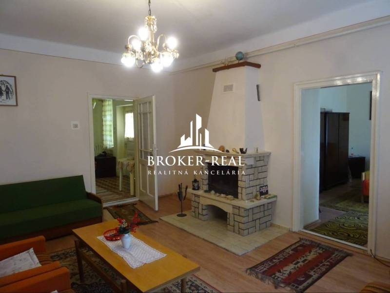 Wohnzimmer in einem Einfamilienhaus mit Kamin, Holzboden und Kronleuchter.