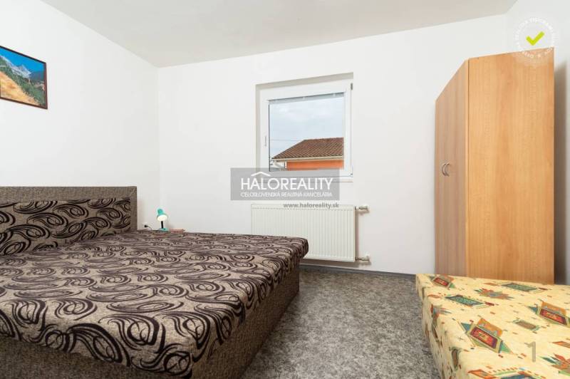 Ein Zimmer in einem Hotel oder einer Pension mit einem einzigartigen Bettmuster und einem Wandbild.