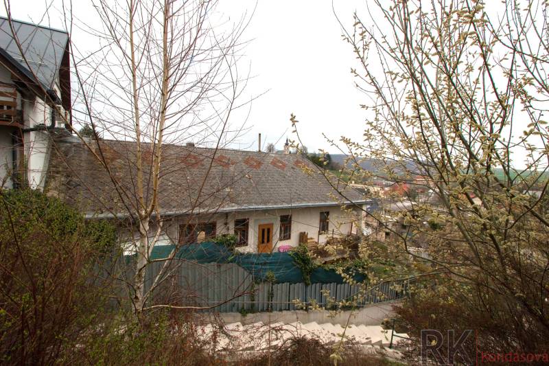 Ein nasses Familienhaus in Kostoľany nad Hornádom, umgeben von Grün und Sträuchern.