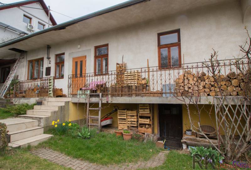 Ein Einfamilienhaus in Kostoľany nad Hornádom, mit Holz auf der Terrasse und einem Garten.