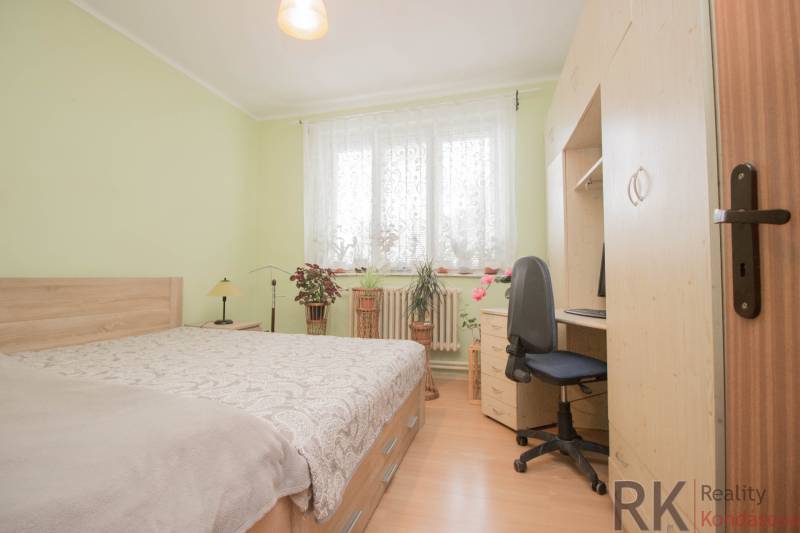 Schlafzimmer in einem Einfamilienhaus mit Holzboden, Bett und Schreibtisch.