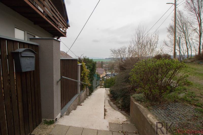 Zugangspfad zu einem Einfamilienhaus in Kostoľany nad Hornádom, umgeben von einem Holzzaun.
