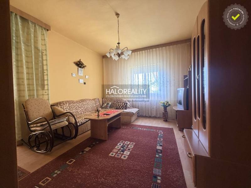 Wohnzimmer in einem Einfamilienhaus mit einem bequemen Sofa und einem Boden in Holzoptik.