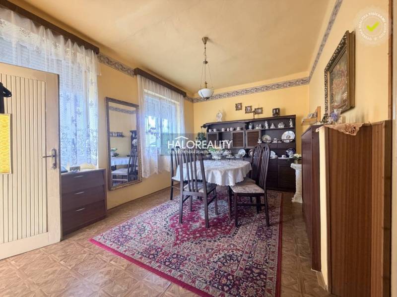 Esszimmer in einem Einfamilienhaus mit Holzboden, dekoriertem Teppich und Tisch.