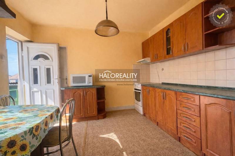 Küche eines Einfamilienhauses mit Holzdekor und sonnigem Wanddekor.