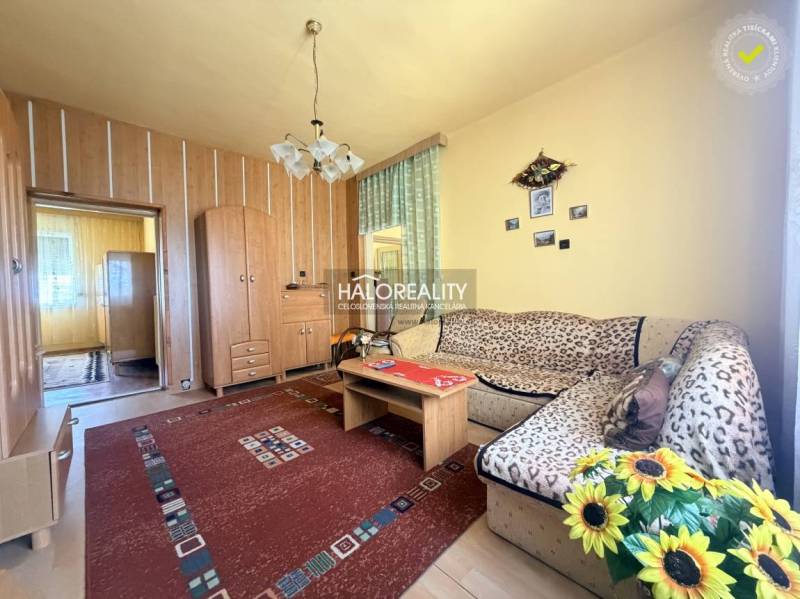 Wohnzimmer in einem Einfamilienhaus mit Holzboden und Blumen.