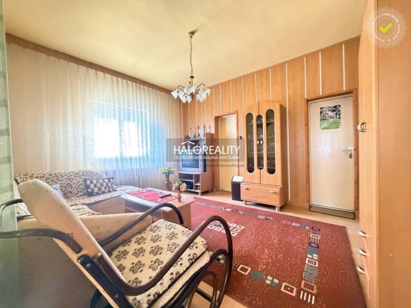 Wohnzimmer in einem Einfamilienhaus mit Licht aus dem Fenster, Holzwanddekoration und Möbel.