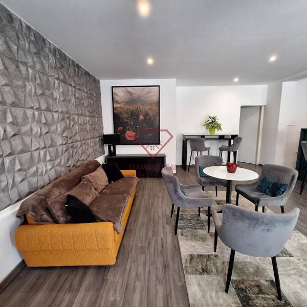 Wohnzimmer in einem Einfamilienhaus mit bequemen Sofa und Essstühlen.