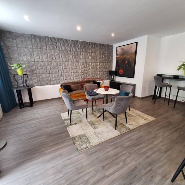 Wohnzimmer mit Sesseln und Sofa in einem Einfamilienhaus, dekorative Wand und Bartheke.