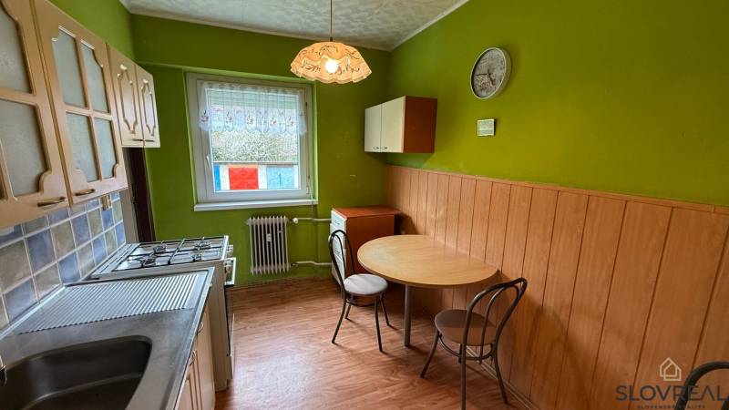 Küche in einer 3-Zimmer-Wohnung mit Holzboden und grünen Wänden.