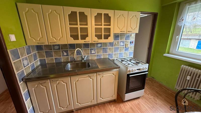 Küche mit Fliesen und Holzboden in einer 3-Zimmer-Wohnung.