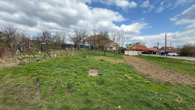 Grundstück auf dem Schwarzen Moor in Pukanec mit gepflegtem Garten und nahegelegenen Häusern.