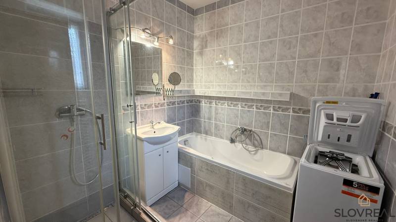 Badezimmer in einer 3-Zimmer-Wohnung mit Badewanne, Dusche und Waschmaschine.