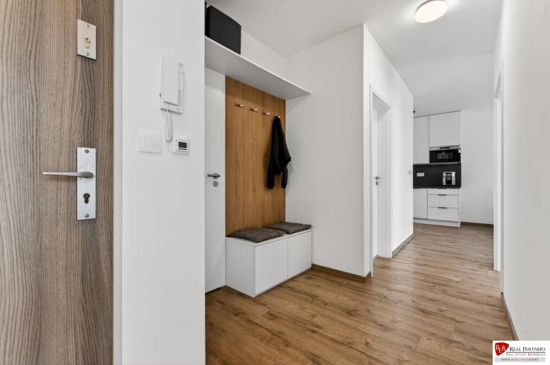 Eingangsflur in einer 2-Zimmer-Wohnung mit Holzboden und eingebautem Stauraum.