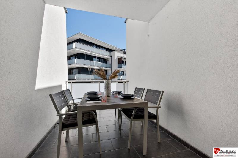 Der Balkon einer 2-Zimmer-Wohnung in der Orechová-Straße in Dunajská Lužná mit einem Außentisch und Stühlen.