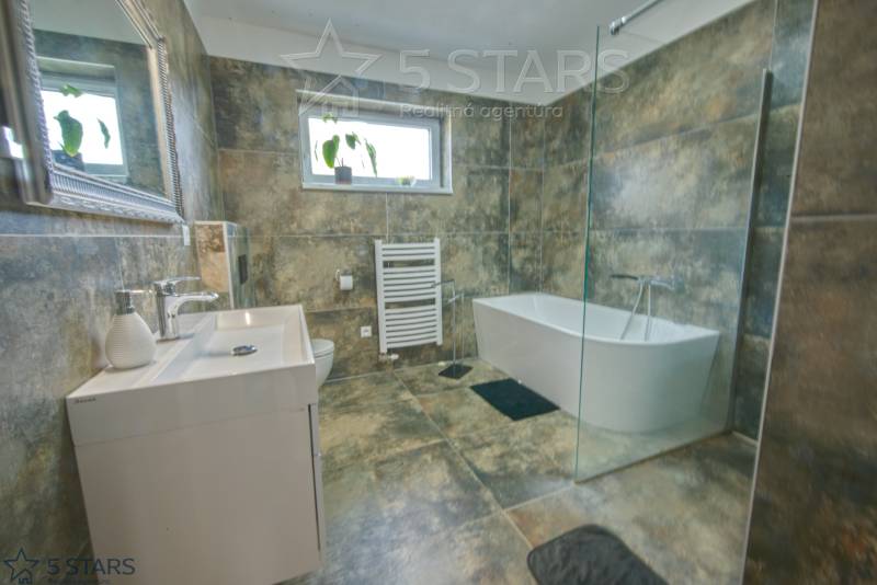 Badezimmer mit einer Duschkabine aus Glas und einer Badewanne in einem Einfamilienhaus.