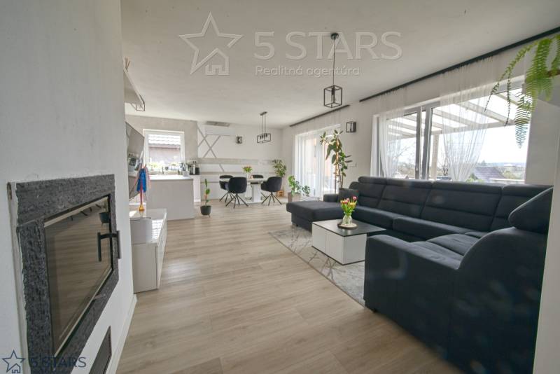 Wohnzimmer in einem Einfamilienhaus mit großem Sofa und Holzboden.