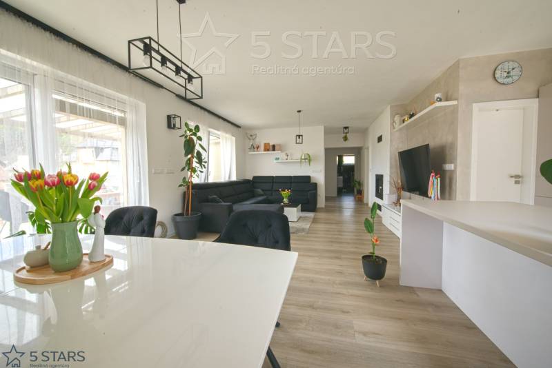 Innenraum eines Einfamilienhauses mit Holzboden, Esstisch und Sofa.