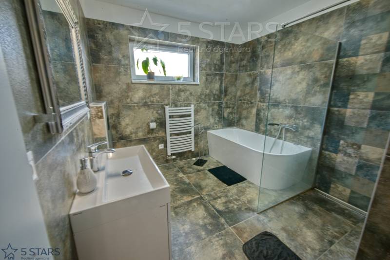 Badezimmer mit Badewanne, Dusche und Fliesen im Einfamilienhaus.