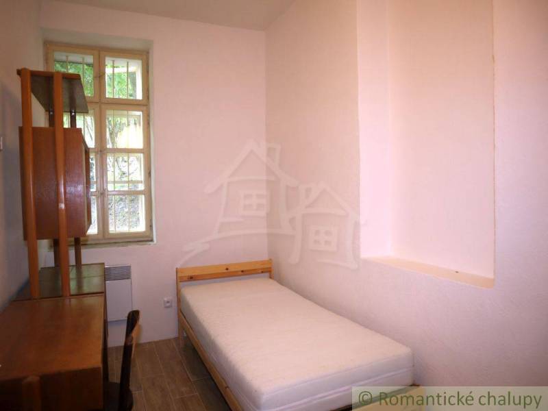 Einfaches Schlafzimmer mit einem Einzelbett und Holzmöbeln in einem Einfamilienhaus.
