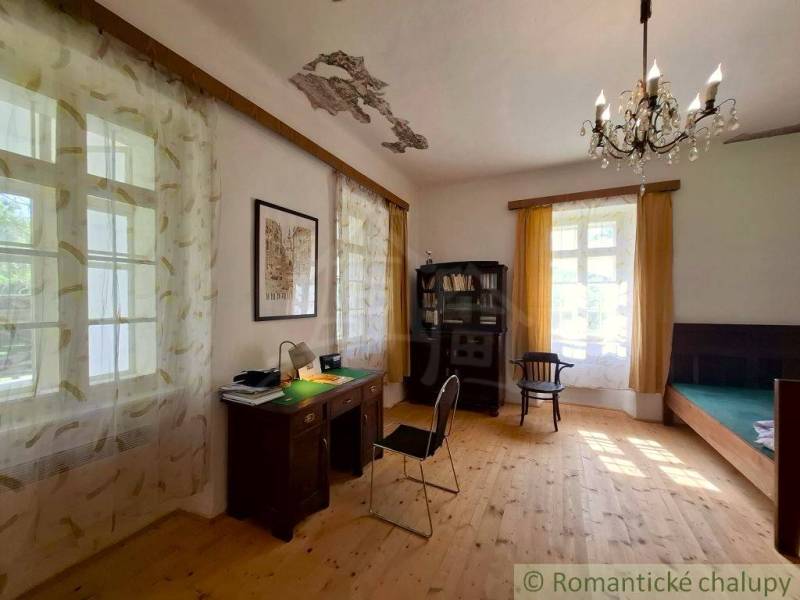 Innenraum eines Einfamilienhauses mit Schreibtisch, Regal und Boden in Holzoptik.
