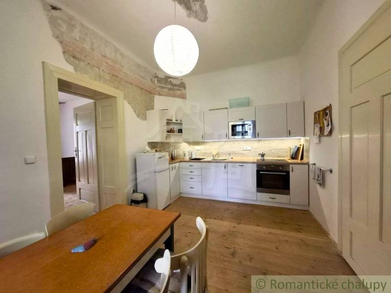 Küche mit weißen Möbeln und einem Boden in Holzoptik in einem Einfamilienhaus.