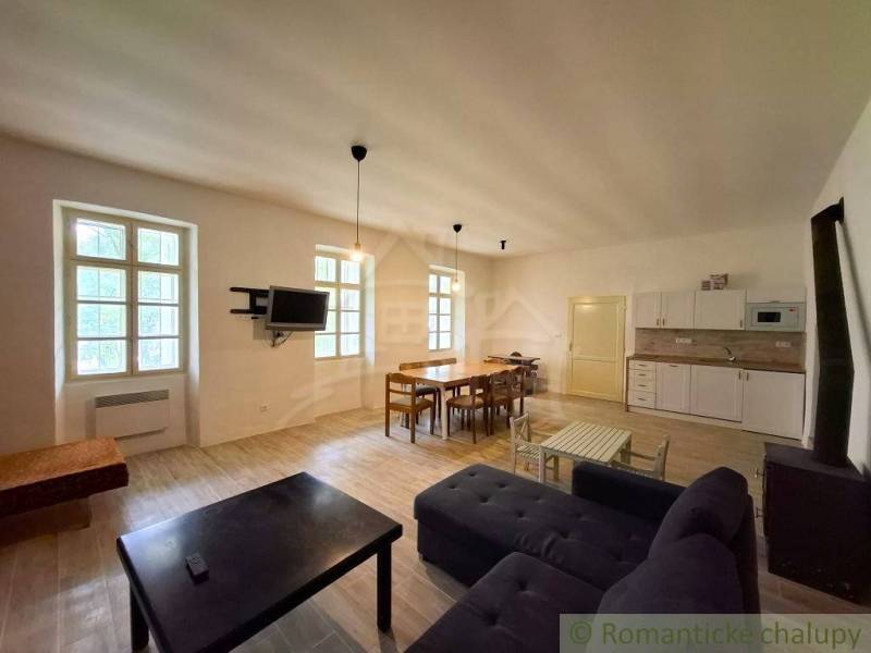 Wohnzimmer mit Küche im Einfamilienhaus, Holzboden, Esstisch, Sofa.