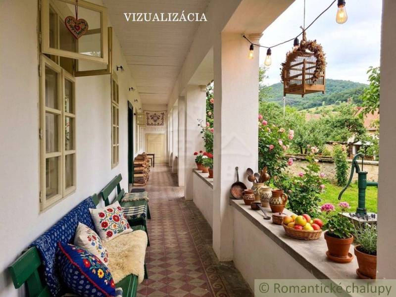 Die Veranda des Einfamilienhauses in Dobroč mit Dekorationen, Kissen und Blick auf den Garten.