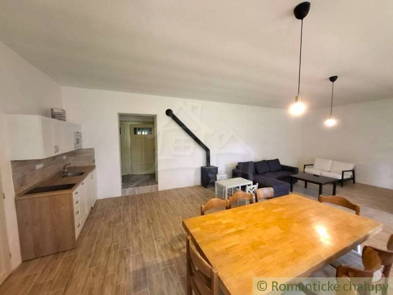 Wohnzimmer in einem Einfamilienhaus mit Holzboden, Kamin und Sofas.