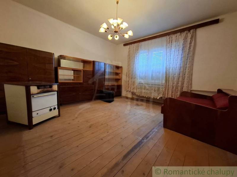 Wohnzimmer in einem Einfamilienhaus mit Holzdekor, Vorhängen und Sofa.