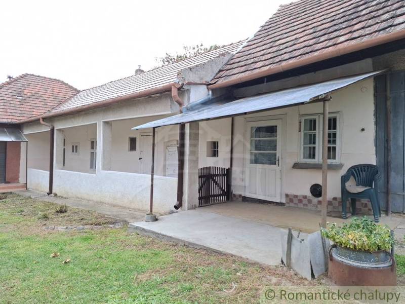 Altes Haus in Mužla mit Terrasse und Holzdach.