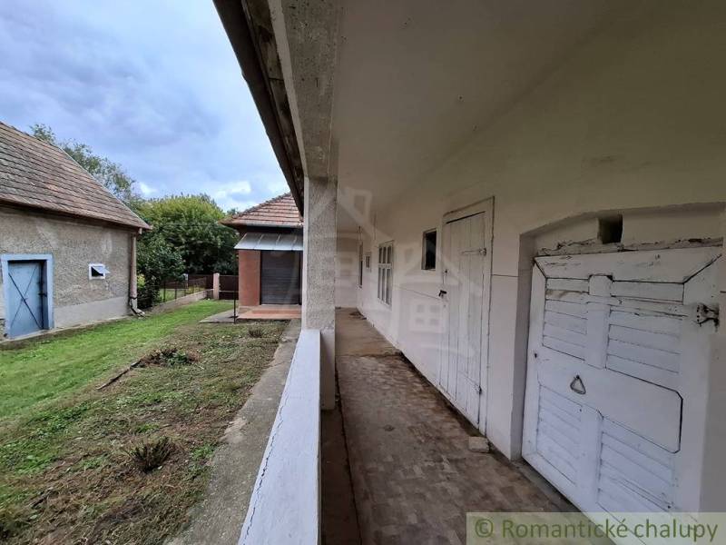 Ein Einfamilienhaus in Mužla mit Veranda und Garten, im ländlichen Stil und einfacher Architektur.