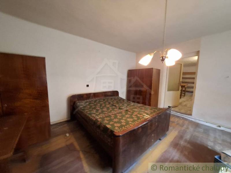 Schlafzimmer in einem Einfamilienhaus mit Holzschränken und Boden mit Holzdekor.