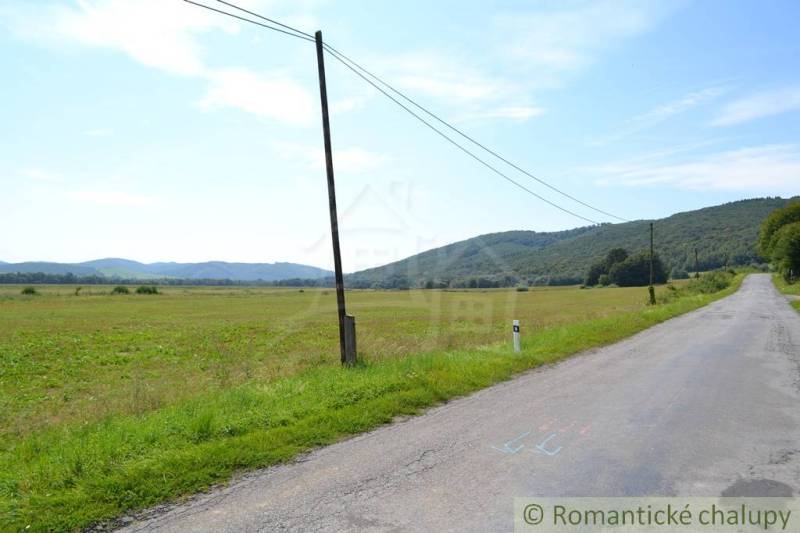 Weitläufige landwirtschaftliche und forstwirtschaftliche Flächen bei der Stadt Šandal mit Blick auf die hügelige Landschaft.
