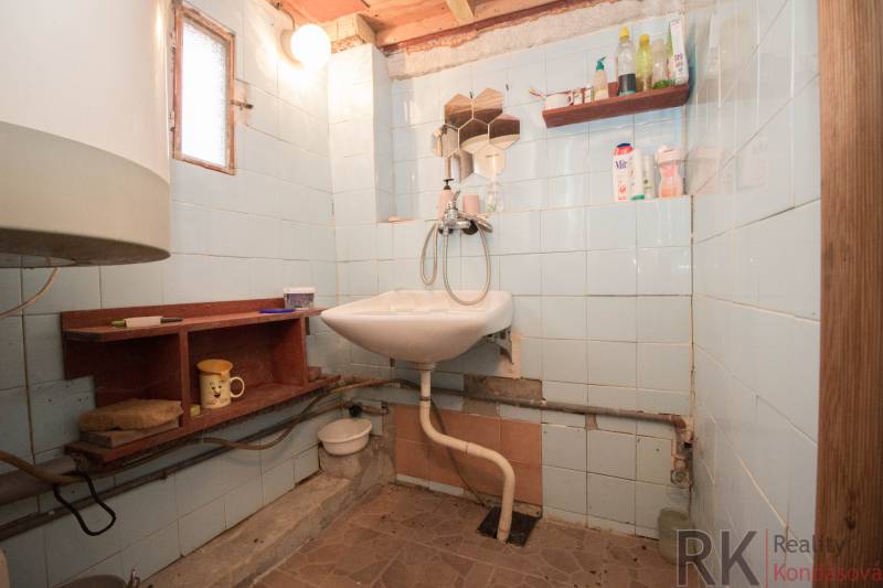 Badezimmer mit Waschbecken, Regalen und Licht, geeignet für Erholungsgrundstücke.