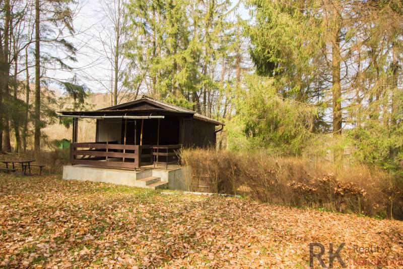 Eine Hütte umgeben von Wald auf Erholungsgrundstücken in Holčíkovce im Herbst.