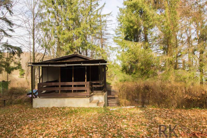 Eine Holzhütte umgeben von Bäumen auf Erholungsgrundstücken in Holčíkovce.